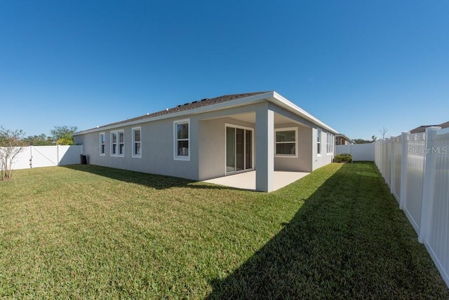 rear view of house with a lawn and a patio