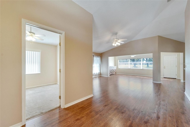 unfurnished living room featuring ceiling fan, wood-type flooring, and vaulted ceiling