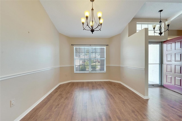 interior space with a chandelier, a textured ceiling, and hardwood / wood-style flooring