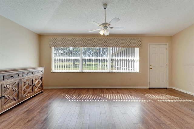 unfurnished room with a textured ceiling, hardwood / wood-style flooring, and ceiling fan