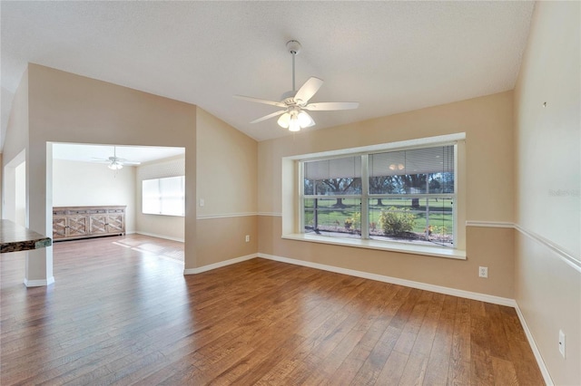 unfurnished room featuring wood-type flooring, a textured ceiling, vaulted ceiling, and ceiling fan