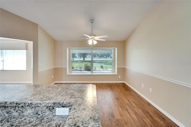 unfurnished room with a textured ceiling, hardwood / wood-style flooring, and ceiling fan