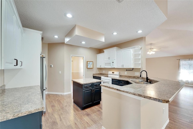 kitchen featuring kitchen peninsula, white cabinetry, light hardwood / wood-style flooring, and white appliances