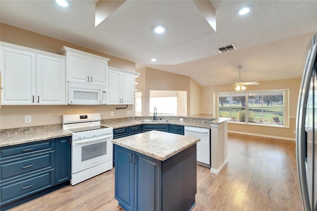 kitchen with white appliances, blue cabinets, a center island, white cabinetry, and lofted ceiling