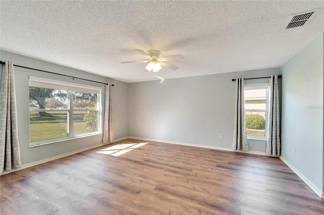 unfurnished room with ceiling fan, a textured ceiling, and light hardwood / wood-style flooring