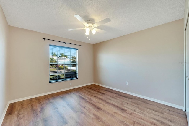 spare room with ceiling fan, light hardwood / wood-style flooring, and a textured ceiling