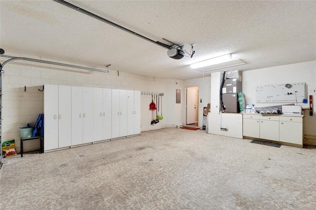 garage with heating unit, electric panel, and a garage door opener