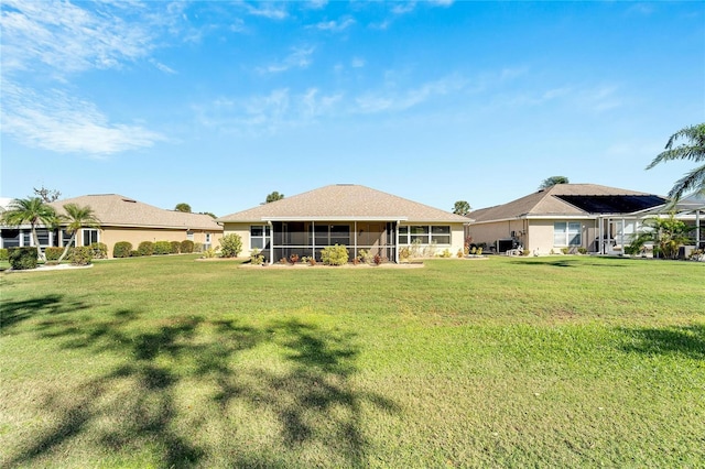 back of property with a sunroom and a yard