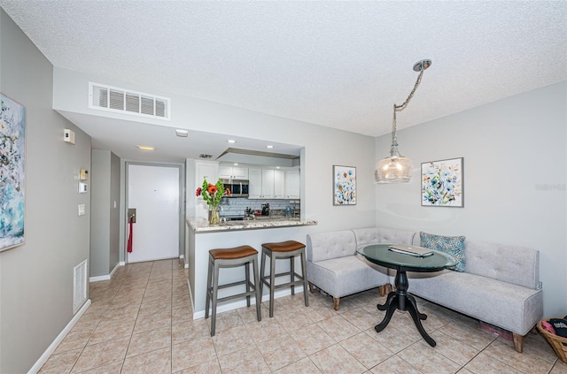 tiled dining space featuring a textured ceiling