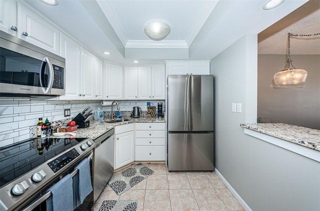 kitchen featuring white cabinets, crown molding, light stone countertops, tasteful backsplash, and stainless steel appliances