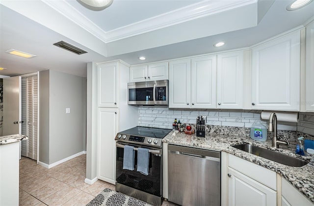 kitchen with crown molding, sink, decorative backsplash, white cabinetry, and stainless steel appliances