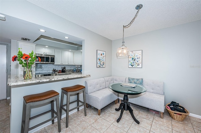 tiled dining area with a textured ceiling