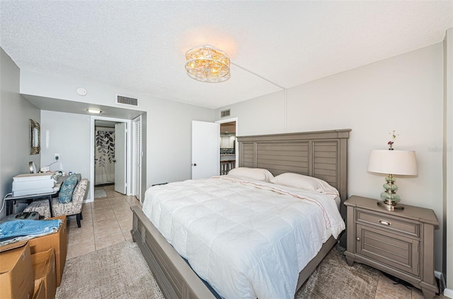 bedroom featuring light tile patterned floors and a textured ceiling