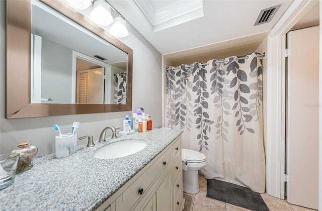 bathroom featuring tile patterned flooring, vanity, toilet, and a skylight