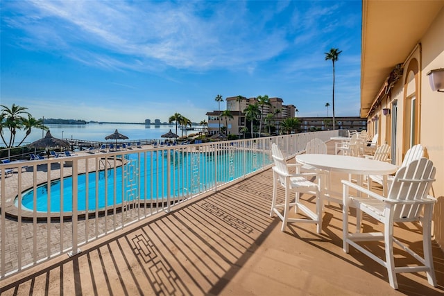 view of pool featuring a patio area and a water view