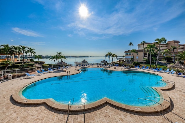 view of pool featuring a patio area and a water view