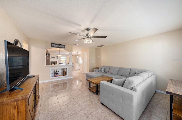 living room with a textured ceiling and ceiling fan with notable chandelier