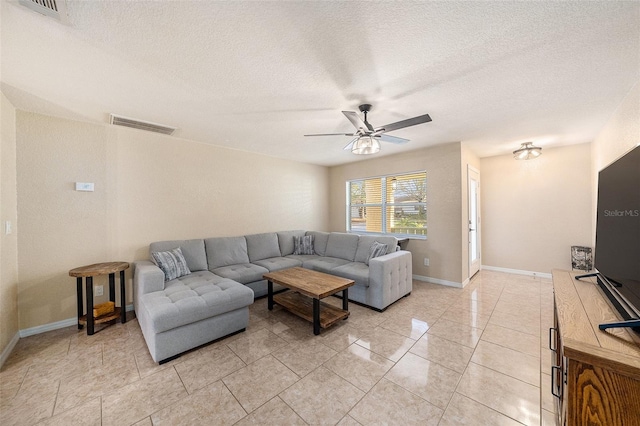 tiled living room with a textured ceiling and ceiling fan