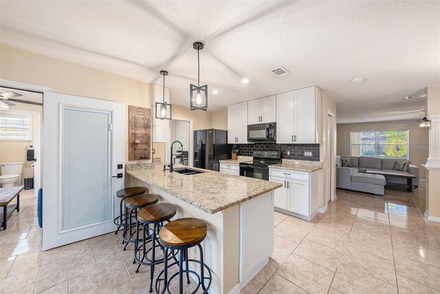 kitchen featuring backsplash, kitchen peninsula, decorative light fixtures, white cabinets, and black appliances