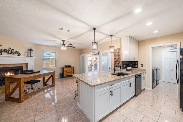 kitchen with appliances with stainless steel finishes, white cabinetry, pendant lighting, and sink