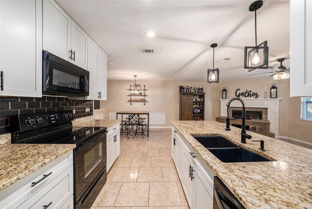 kitchen featuring white cabinetry, sink, ceiling fan, decorative light fixtures, and black appliances