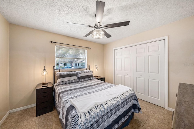 bedroom featuring ceiling fan, light tile patterned floors, a textured ceiling, and a closet