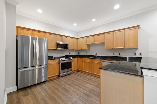 kitchen with stainless steel appliances, dark stone countertops, hardwood / wood-style flooring, kitchen peninsula, and crown molding