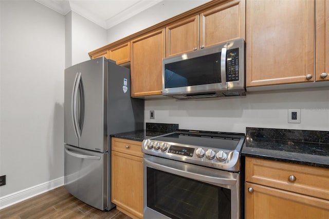 kitchen featuring appliances with stainless steel finishes, dark stone countertops, crown molding, and dark hardwood / wood-style floors