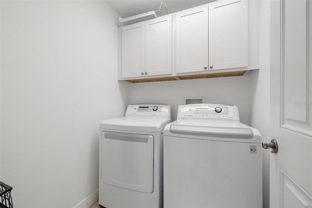 washroom with washing machine and dryer and cabinets