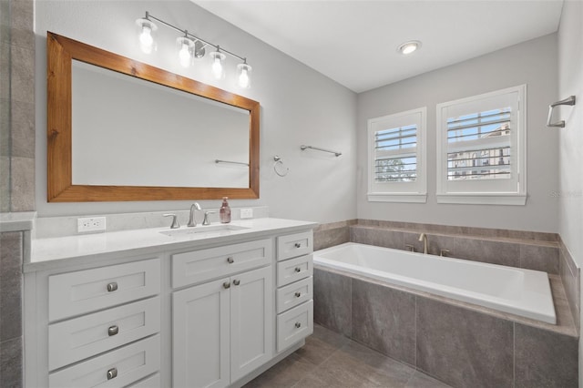 bathroom with tiled bath and vanity