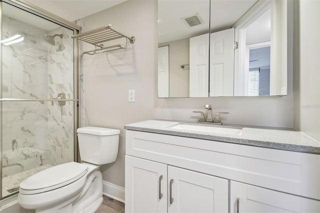 bathroom with vanity, an enclosed shower, and toilet