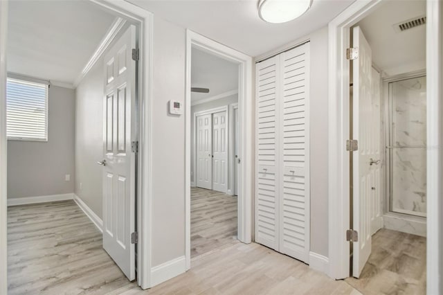 corridor featuring light hardwood / wood-style flooring and ornamental molding