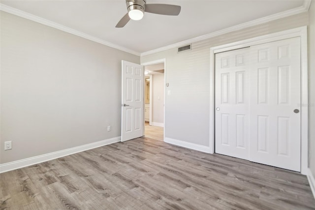 unfurnished bedroom with ceiling fan, a closet, ornamental molding, and light hardwood / wood-style flooring