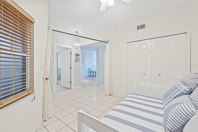 tiled bedroom featuring ceiling fan and a closet