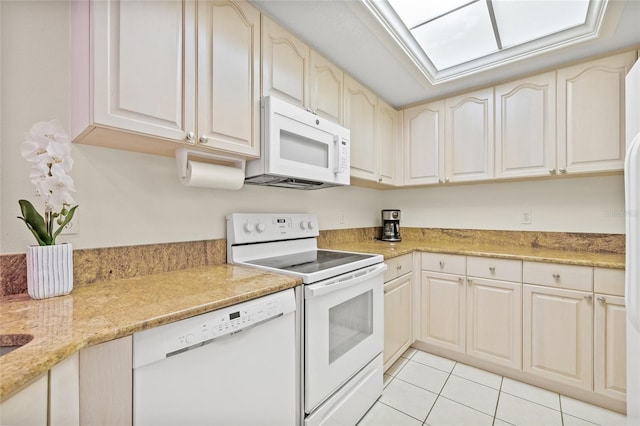 kitchen with light stone countertops, white appliances, and light tile patterned floors