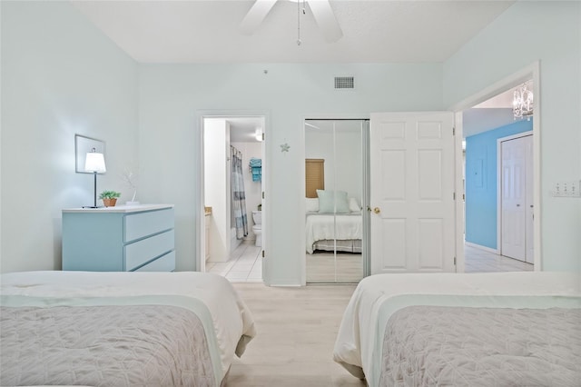 bedroom with light hardwood / wood-style floors, ensuite bath, and ceiling fan