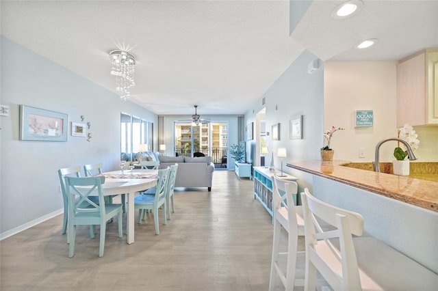 dining room featuring a ceiling fan, light wood-type flooring, baseboards, and recessed lighting