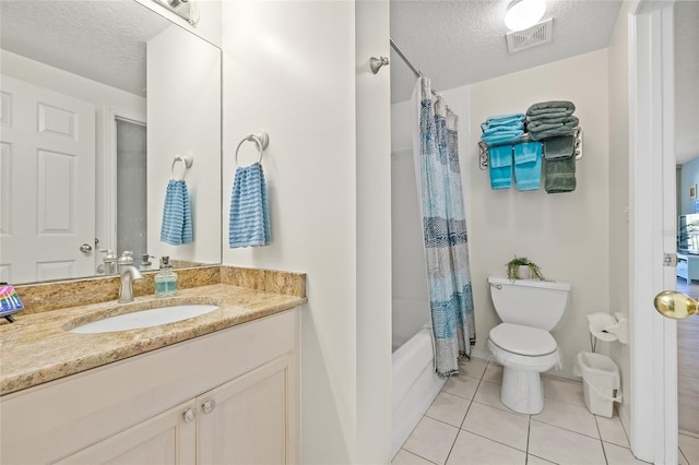 bathroom featuring a textured ceiling, toilet, visible vents, vanity, and tile patterned floors