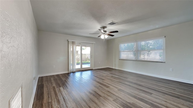 spare room featuring a textured ceiling, ceiling fan, and dark wood-type flooring