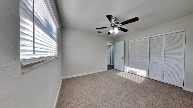 unfurnished bedroom featuring ceiling fan, a closet, and carpet