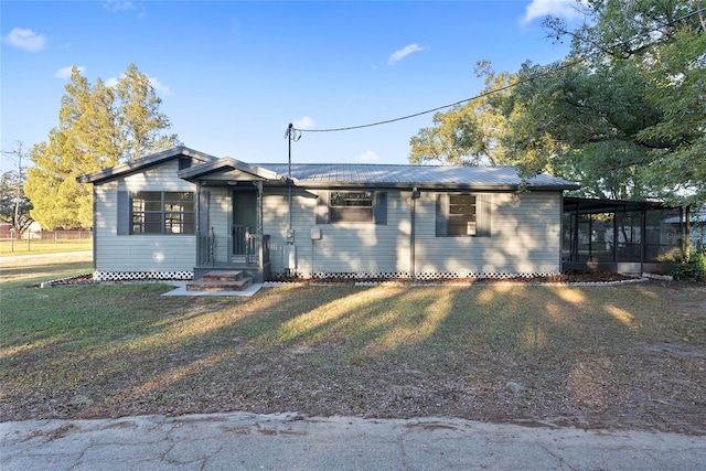 ranch-style home featuring a sunroom and a front lawn