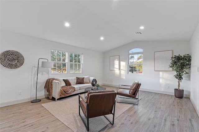 living room featuring vaulted ceiling and light hardwood / wood-style flooring