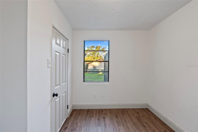 unfurnished room featuring hardwood / wood-style floors and a textured ceiling