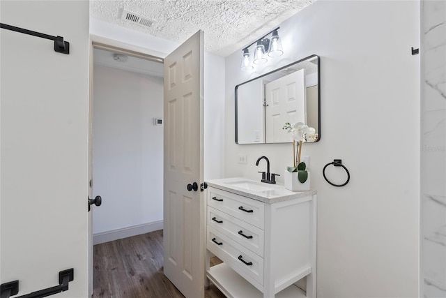 bathroom featuring vanity, hardwood / wood-style floors, and a textured ceiling