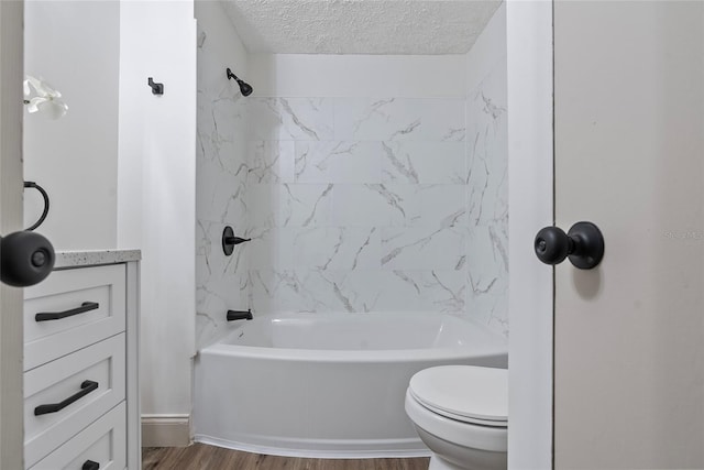 full bathroom with toilet, tiled shower / bath, wood-type flooring, a textured ceiling, and vanity