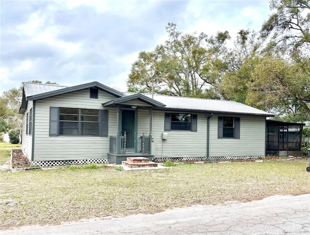 view of front of property featuring a sunroom and a front yard