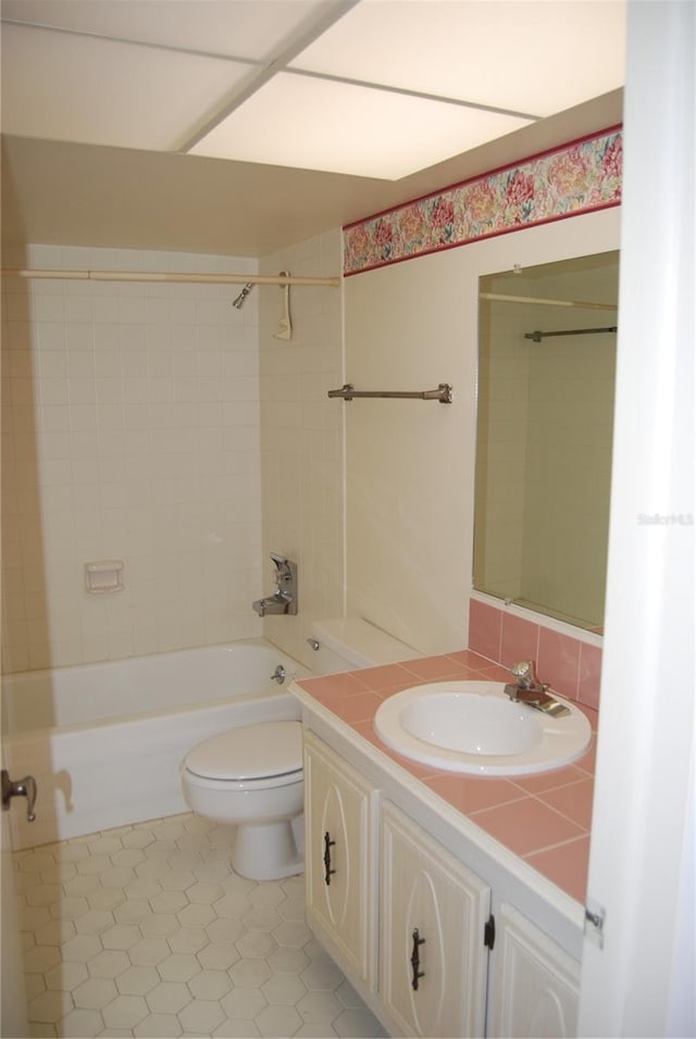 full bathroom with vanity, tile patterned floors, tiled shower / bath combo, decorative backsplash, and toilet