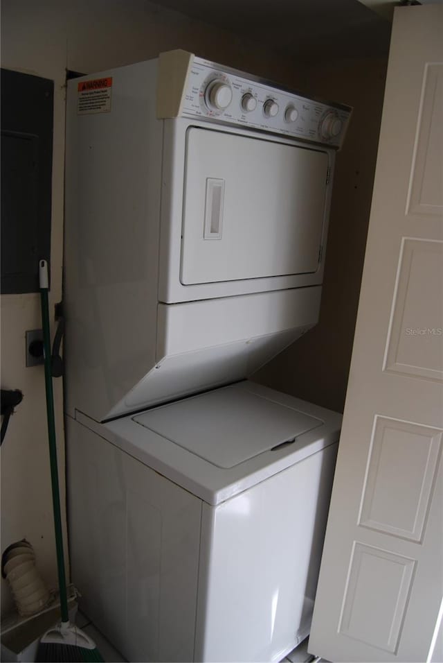 clothes washing area featuring stacked washer and clothes dryer