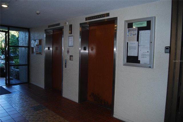 corridor featuring tile patterned floors and elevator