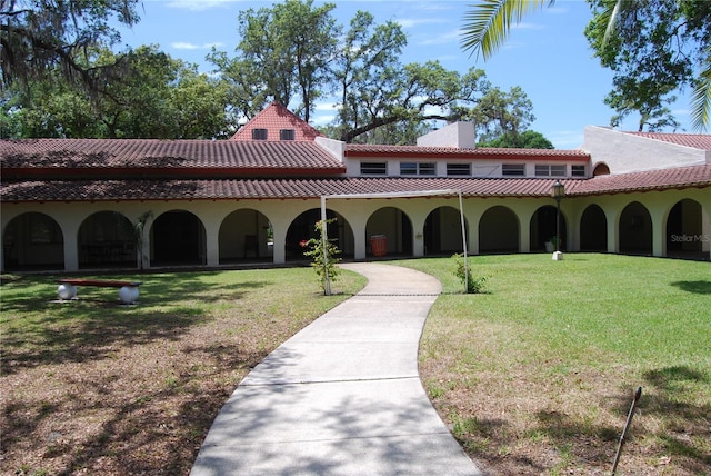 mediterranean / spanish house with a front lawn